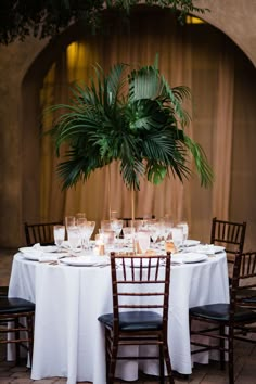 the table is set with white linens and place settings