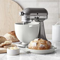 a mixer sitting on top of a counter next to bread