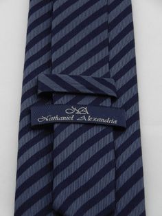 "Mens navy on blue silk striped necktie, perfect for weddings, work or everyday use. Available as a extra long tie Handmade from 100% silk, this special collection features a .75\" Eds Neckties logo at the bottom right front corner of every tie and a larger logo located on the tipping (Back of the tie). The label features the collection name (Nathaniel Alexandria) Named after my son Nathaniel and my daughter Alexandria. Expertly hand-made from 100% silk you can select your length from 57\" to 65 Pinstripe Business Tie, Business Pinstripe Standard Tie, Pinstripe Ties For Formal Occasions, Striped Standard Tie For Formal Occasions, Elegant Striped Suit And Tie Accessories For Black Tie, Elegant Pinstripe Standard Tie, Striped Business Neckwear Ties, Striped Business Neckwear, Navy Suit And Tie Accessories For Formal Occasions