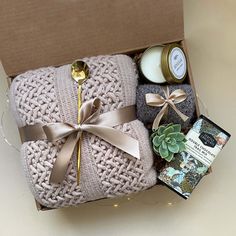 a wrapped gift box with candles, cookies and other items