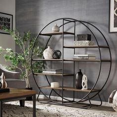 a living room filled with furniture next to a wall mounted book shelf on top of a rug