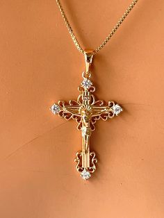 This is a 18kt gold-filled ornate crucifix cross pendant necklace.  Shown on a shiny 18kt gold filled box chain that measures 18" length.  his beautiful crucifix measures 35x20mm with bale. Please not that 18k gold filled is deeper in gold color, almost a pinkish gold.  Ships in a cute gift box ready to present. Gold filled jewelry is an actual layer of gold pressure bonded to another metal. Gold filled is not to be confused with gold plating as filled has 100% more gold than gold plating. Gold Yellow Gold Cubic Zirconia Crucifix Jewelry, Yellow Gold Crucifix Jewelry With Cubic Zirconia, Gold Cubic Zirconia Cross Necklace As A Gift, Gold Cubic Zirconia Crucifix Necklace, Gold Plated Crucifix Jewelry Gift, Cubic Zirconia Crucifix Jewelry Gift, Cubic Zirconia Crucifix Necklace For Gift, Gold Crucifix For Anniversary, Cross Pendant Necklace Woman