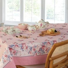 the table is covered with pink flowers and teacups, along with other dishes