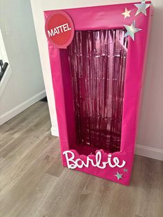 a pink box with the word barbie written on it and stars hanging from it's side