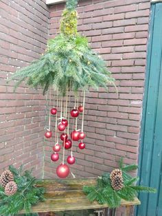 a christmas tree with red balls hanging from it's branches and pine cones on top