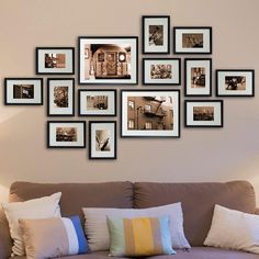 a living room filled with lots of framed pictures on the wall above a brown couch