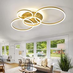 a living room filled with furniture and a ceiling light above the couches in front of large windows