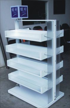 a large white shelf with several drawers on it's sides and two signs above the shelves