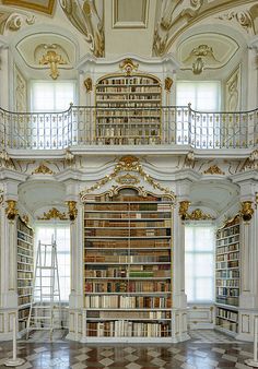 an ornate room with many bookshelves and stairs