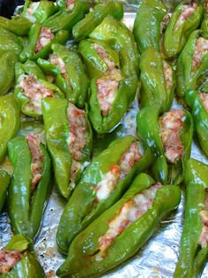 green peppers with meat on them are sitting on tin foil and ready to be cooked