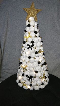 a christmas tree made out of white and black balls with gold stars on the top