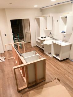 an unfinished room with white cabinets and wood flooring