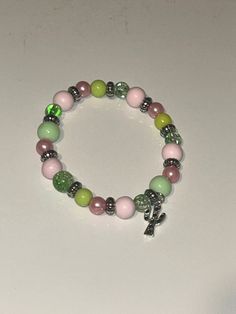 This multi colored bracelet with a cute cactus charm is a great touch to elevate your look Casual Beaded Charm Bracelet, Handmade Casual Stretch Bracelet, Casual Multicolor Hypoallergenic Beaded Bracelets, Adjustable Casual Rosary Bracelet, Casual Multicolor Hypoallergenic Bracelets, Casual Adjustable Crystal Bracelet With Colorful Beads, Casual Beaded Charm Bracelet With Round Beads, Trendy Green Crystal Bracelet With Round Beads, Casual Adjustable Rosary Bracelet With Round Beads