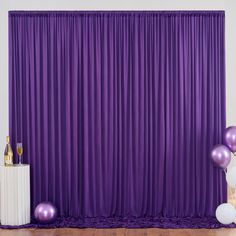 purple curtains and balloons in front of a white backdrop