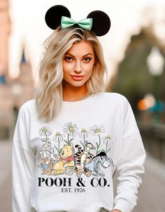 a woman with blonde hair wearing a mickey mouse sweatshirt