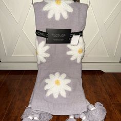 a blanket with white flowers on it sitting on a wooden floor next to a door