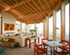 a living room filled with furniture and lots of windows next to a beach side house