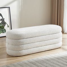 a stack of towels sitting on top of a wooden floor next to a framed photograph