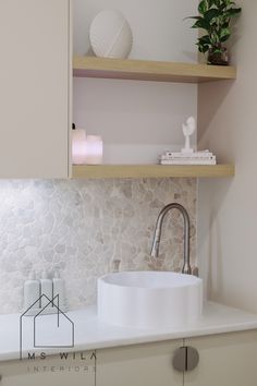 a white sink sitting on top of a counter next to a shelf filled with books