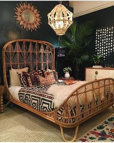 a rattan bed frame in a bedroom with black walls and patterned rugs on the floor