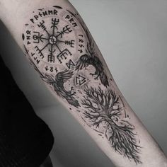 a man's arm with a compass and tree tattoo on the left inner arm