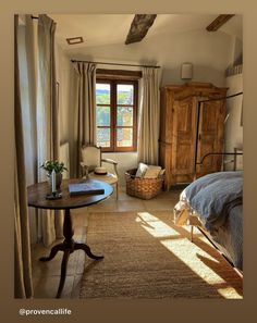 a bedroom with a bed, chair and table in it