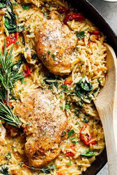 chicken and rice dish in a skillet with wooden spoon on the side, ready to be eaten