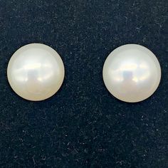 two white pearls sitting on top of a black surface