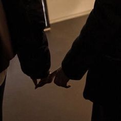 two people holding hands while standing next to each other