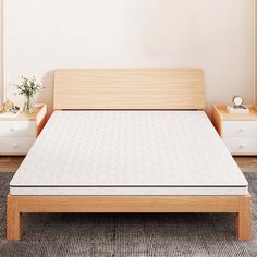 a white mattress sitting on top of a wooden bed frame next to two nightstands