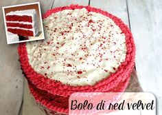 a red velvet cake with white frosting and sprinkles on top, sitting on a wooden table