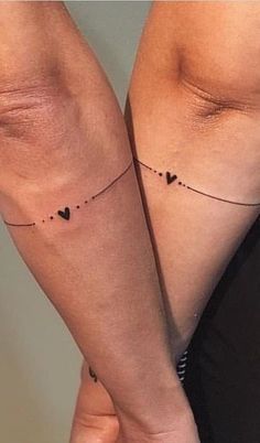 two women with matching tattoos on their legs