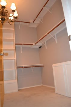 an empty walk in closet with shelves and lights