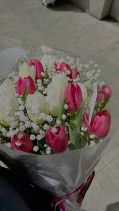 a bouquet of pink and white tulips on a motorcycle