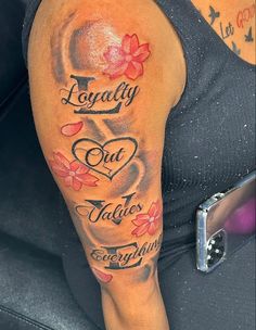 a woman's arm with tattoos and words on it