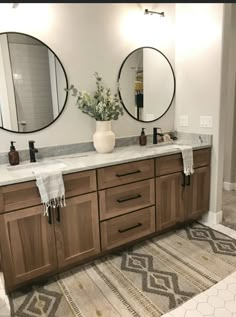 a bathroom with double sinks and mirrors on the wall