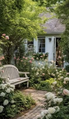 a white bench sitting in the middle of a garden next to some trees and flowers