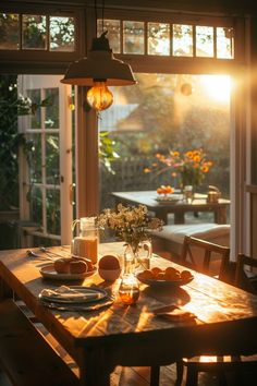 a wooden table with plates and cups on it in front of an open patio door