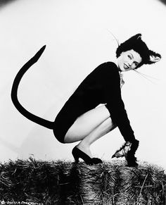 a black and white photo of a woman with a cat costume