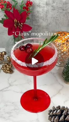 a red cocktail with garnishes in a wine glass on a marble table