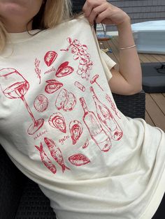 Beach vacay vibes all year! This tee channels La Dolce Vita with playful icons of wine, tomatoes, tinned fish, oysters, and a hint of mermaidcore. It's the perfect summer staple for fans of Italian culture, comfy fits, and bringing that vacation feeling everywhere.   - 100% ring-spun cotton - Medium weight fabric - Relaxed fit - Sewn-in twill label -Inclusive sizing: S-4XL All items are made-to-order: - We do not accept returns, size changes or cancellations. Please read size charts for these it Summer T-shirt With Screen Print For Brunch, Summer Graphic Print T-shirt For Brunch, Summer Graphic Tee For Brunch, Trendy Summer T-shirt For Brunch, Short Sleeve Screen Print Tops For Brunch, Summer Brunch Cotton T-shirt, Summer Cotton T-shirt For Brunch, Cotton T-shirt For Summer Brunch, Graphic Tee With Screen Print For Brunch