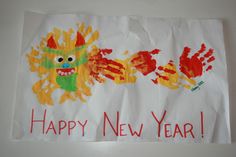 a handprinted happy new year sign with two hands and a monster on it