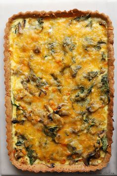 a cheesy quiche with spinach, cheese and onions in a tart crust