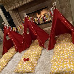 red and yellow bedspreads are on the floor in front of a fire place