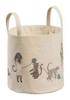 a white storage basket with cats and dogs on the front, one cat is pulling a dog