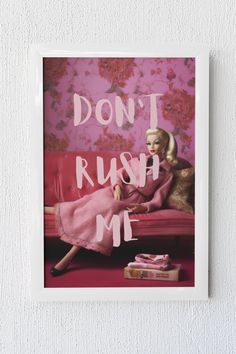 a woman sitting on top of a red couch in front of a pink wall with the words don't rush me