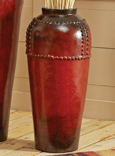 two red vases sitting on top of a wooden table next to each other with toothbrushes in them