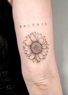 a woman's arm with a sunflower and the word balance tattooed on it