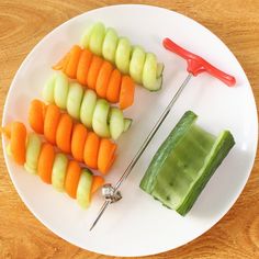 a white plate topped with carrots, celery and cucumber sticks