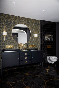 a bathroom with black and gold wallpaper, a white toilet and a large mirror